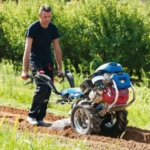 a man ploughing a field using a BCS 738 Two Wheel Tractor