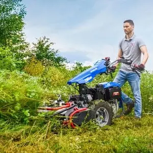 a man cutting thick vegetation using the BCS 780 HY StarGate 2 Wheel Tractor equipped with a flail mower attachment