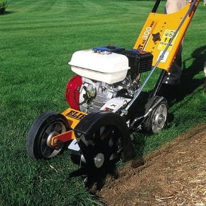 the Eliet KS 300 Pro Petrol Edge Cutter trimming the edge of a lawn, where it meets a planting bed