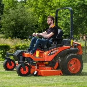 a man with a beard and glasses, cutting grass in a field using the Kubota ZD1211 Diesel Zero-Turn Mower