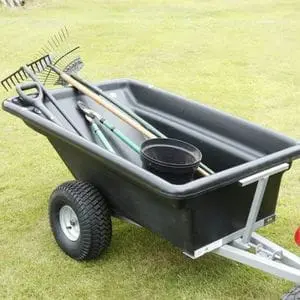 the SCH PTP Plastic Bodied Trailer carrying long-handled gardening tools and a plant pot across a lawn