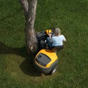 a woman mowing around the base of a tree, using the STIGA Park 500 Petrol Front Mower