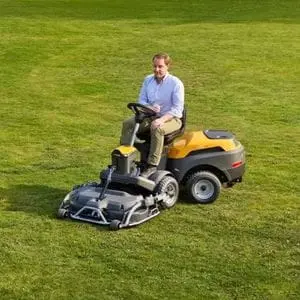 a man sat on the STIGA Park 500 WX Special Front Mower, which is parked in the middle of a well-maintained lawn