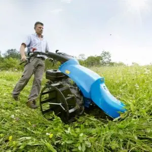 a man cutting long grass using the BCS 706 Petrol Rotavator with Laser Cutter Bar attachment