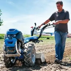 a man using the BCS 706 Petrol Rotavator with Rotary Hoe to prepare soil for planting