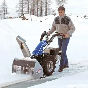 a man clearing snow using the BCS 738 Two Wheel Tractor with snow plough attachment