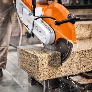 a close up of someone using the STIHL TSA 500 Cordless Cut-Off Machine to cut a block of granite